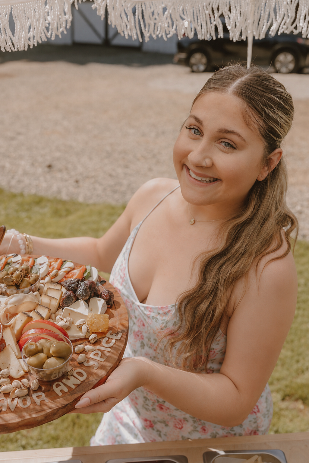 Solyn Farmer smiling while holding one of her charcuterie boards
