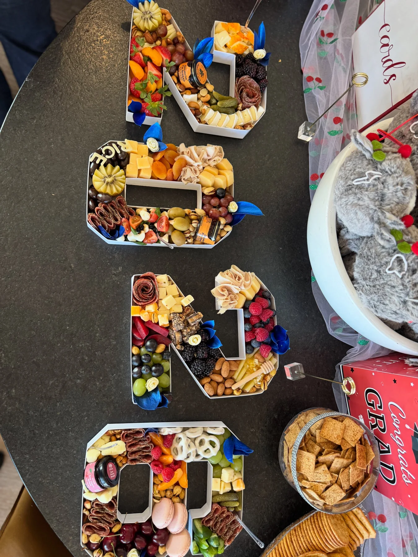 Custom letter-shaped charcuterie boards arranged for a celebration