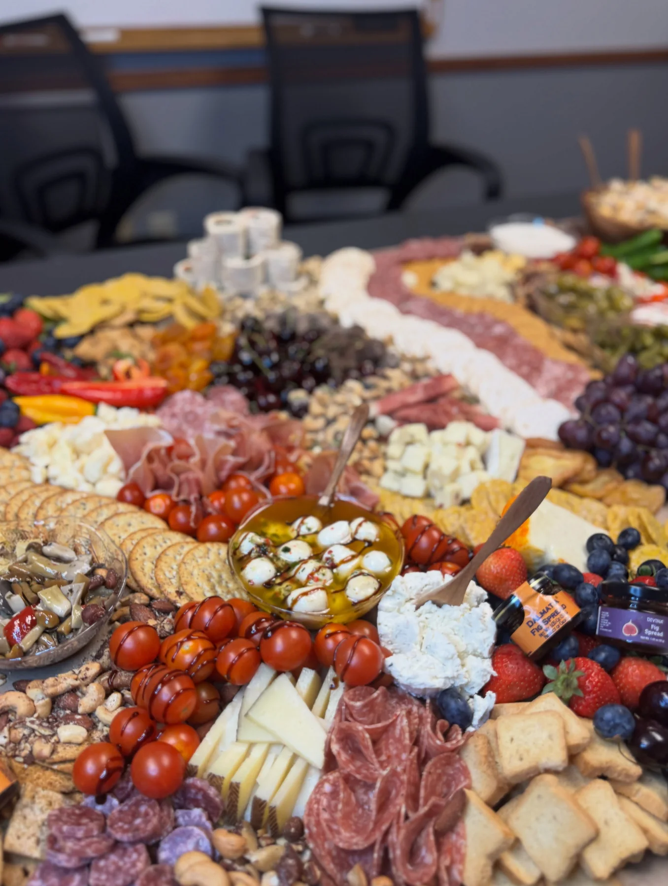 Abundant grazing table with cheeses, meats, fruit, vegetables, crackers, and spreads